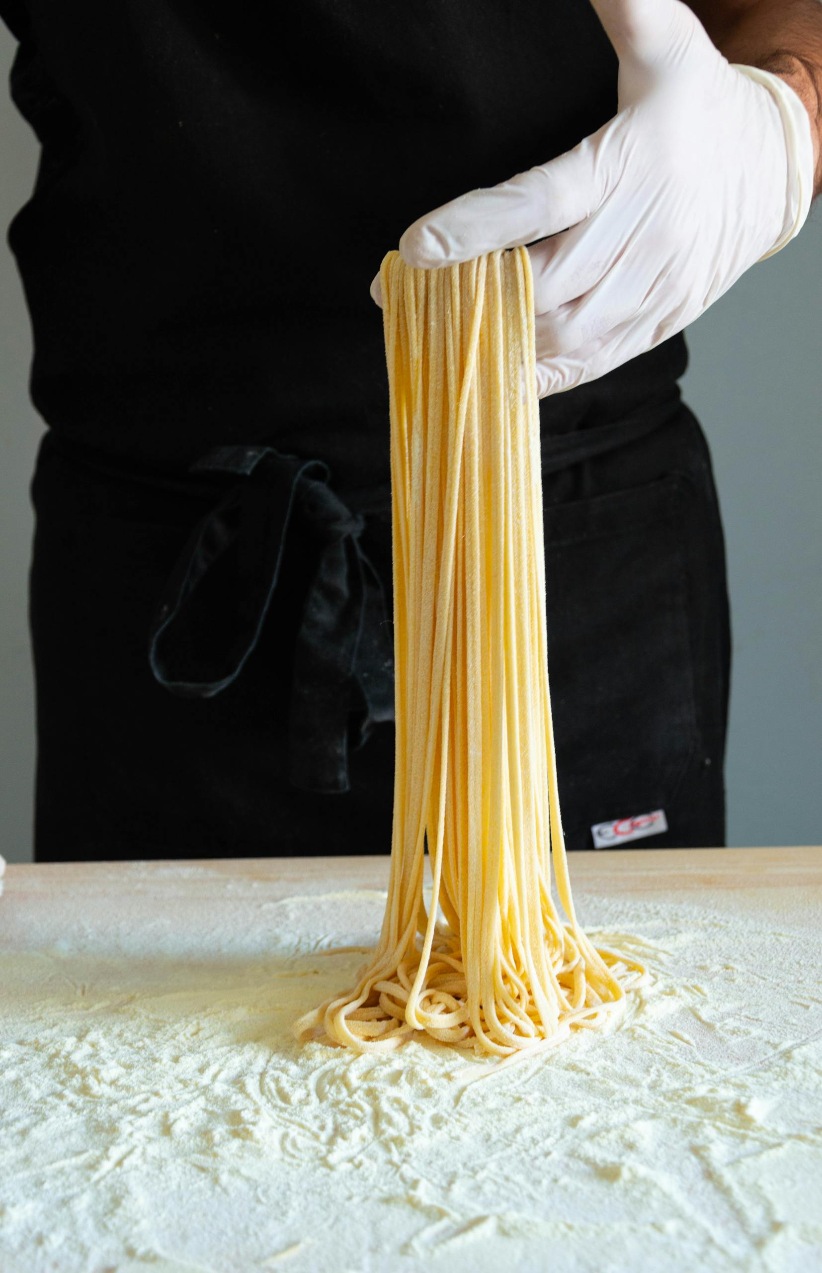 Close-up of fresh handmade spaghetti being prepared indoors. Culinary art in Rome.
