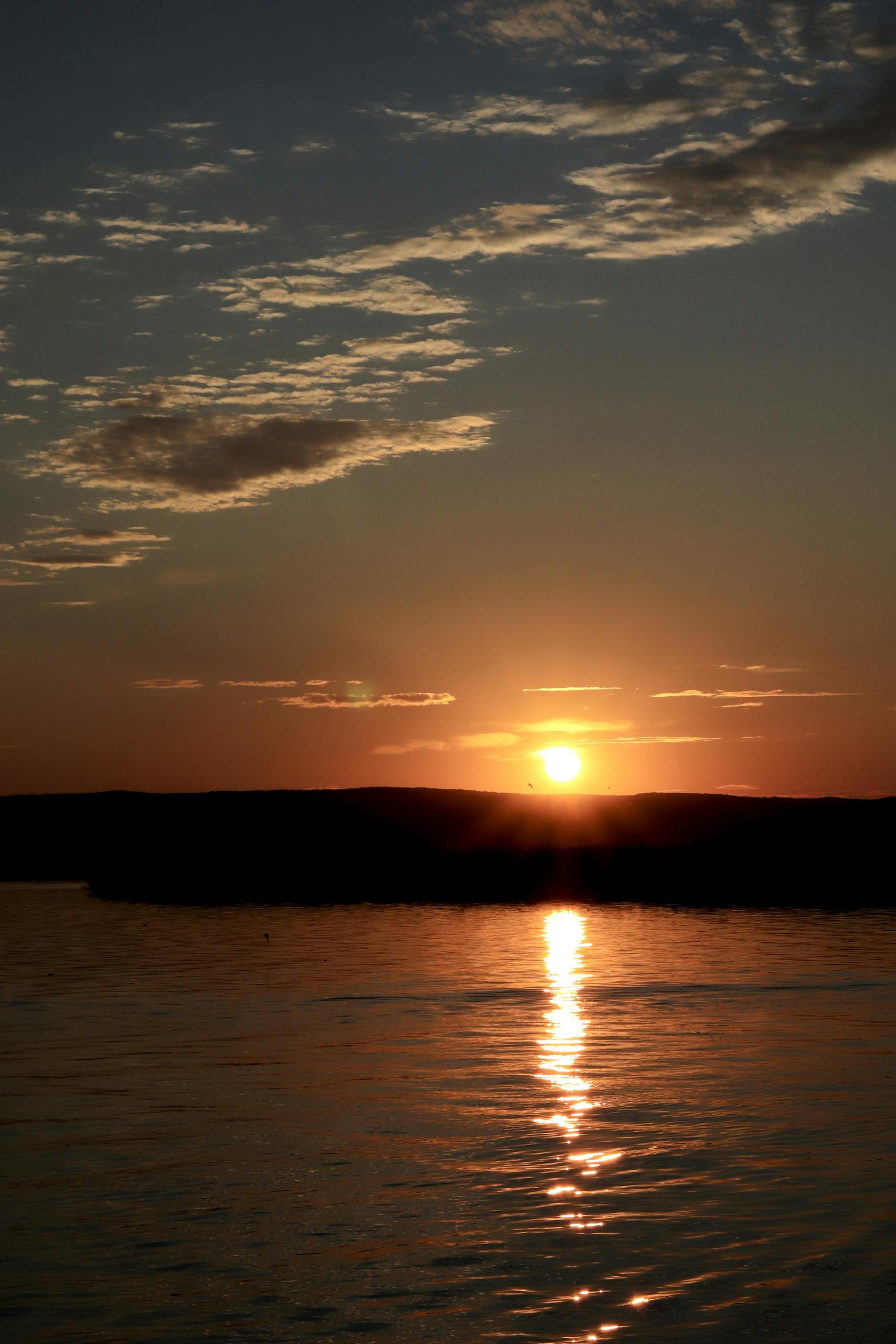 Beautiful sunset over Neusiedl am See in Austria with vibrant orange hues reflecting on the water.
